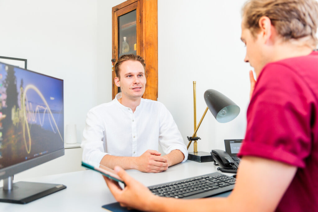 Maximilian Sattler im Gespräch mit Patient | Fachzahnarzt für Oralchirurgie in Marl