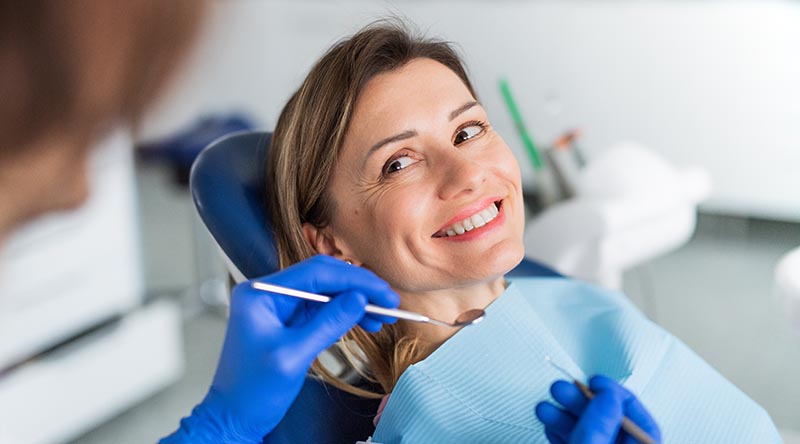 Eine Patientin lässt sich bei ihrem Zahnarzt zu Zahnersatz und den Möglichkeiten beraten.